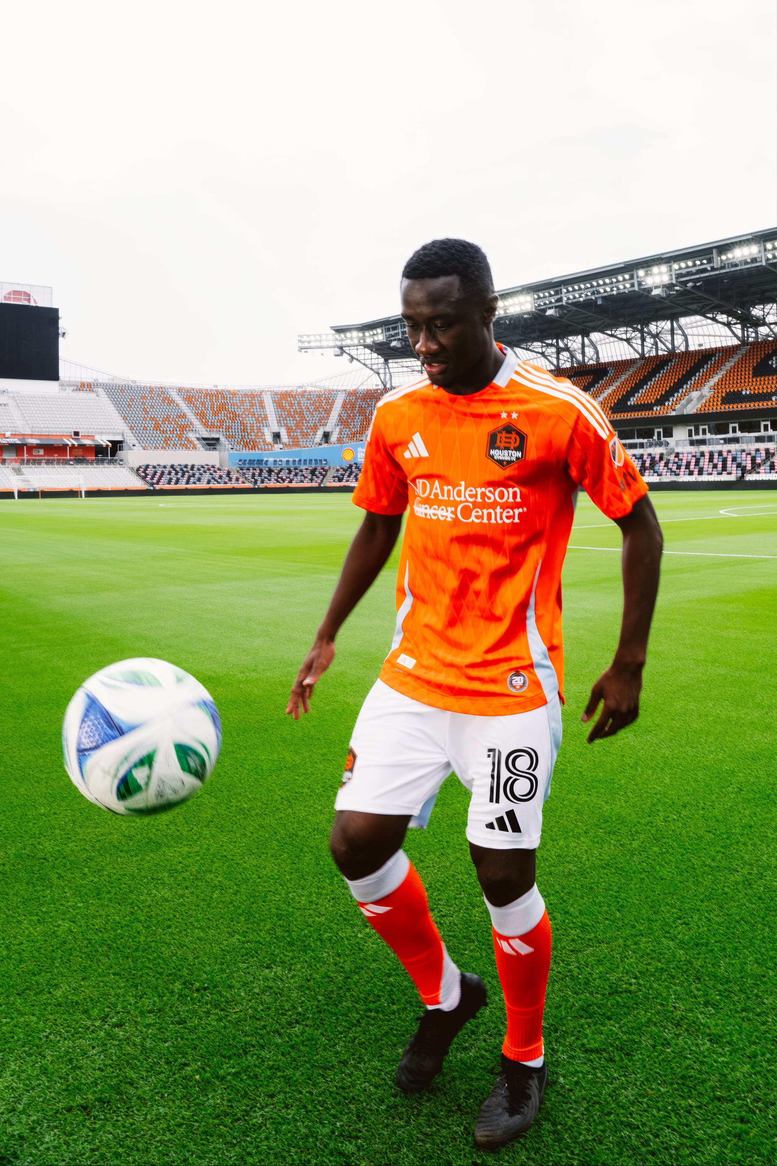 Diadié Samassékou im orangefarbenen Trikot, Porträtaufnahme im Stadion