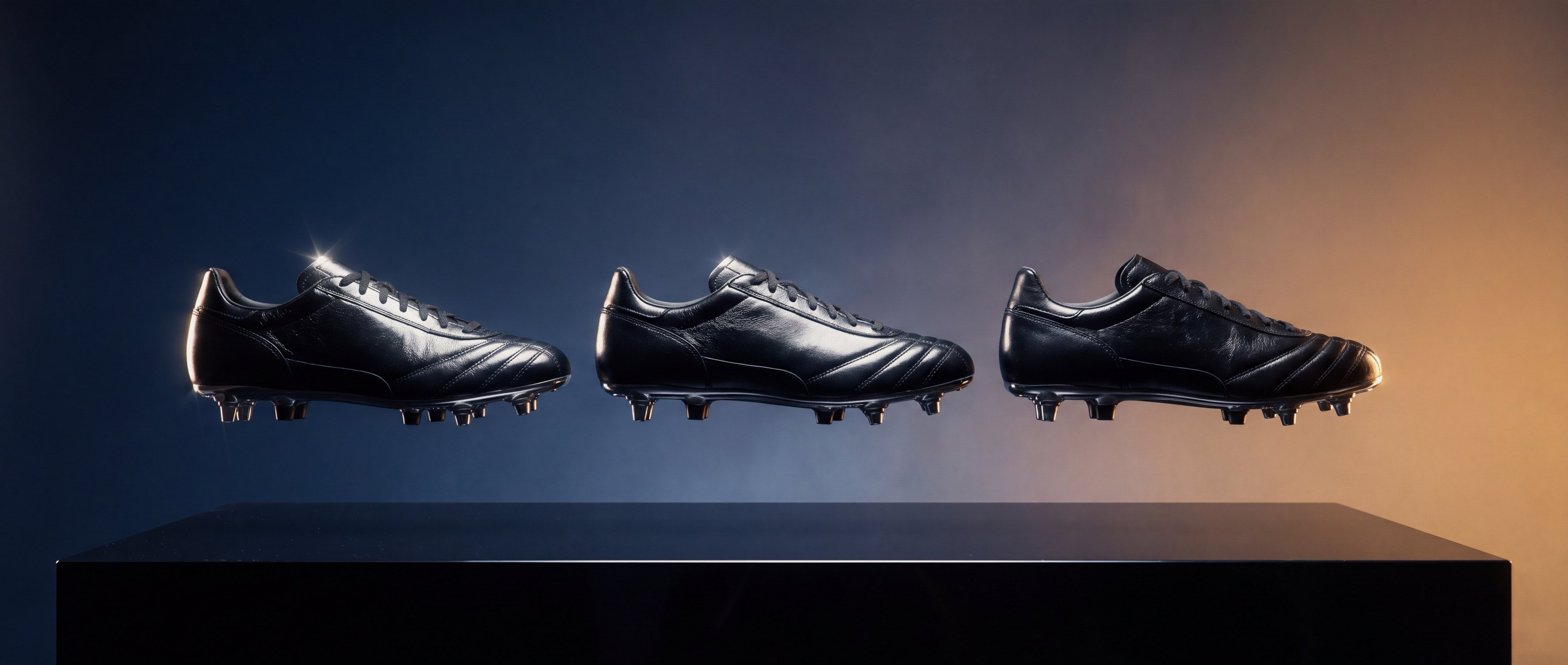 Drei schwarze Lederfußballschuhe schwebend über einem dunklen Podest