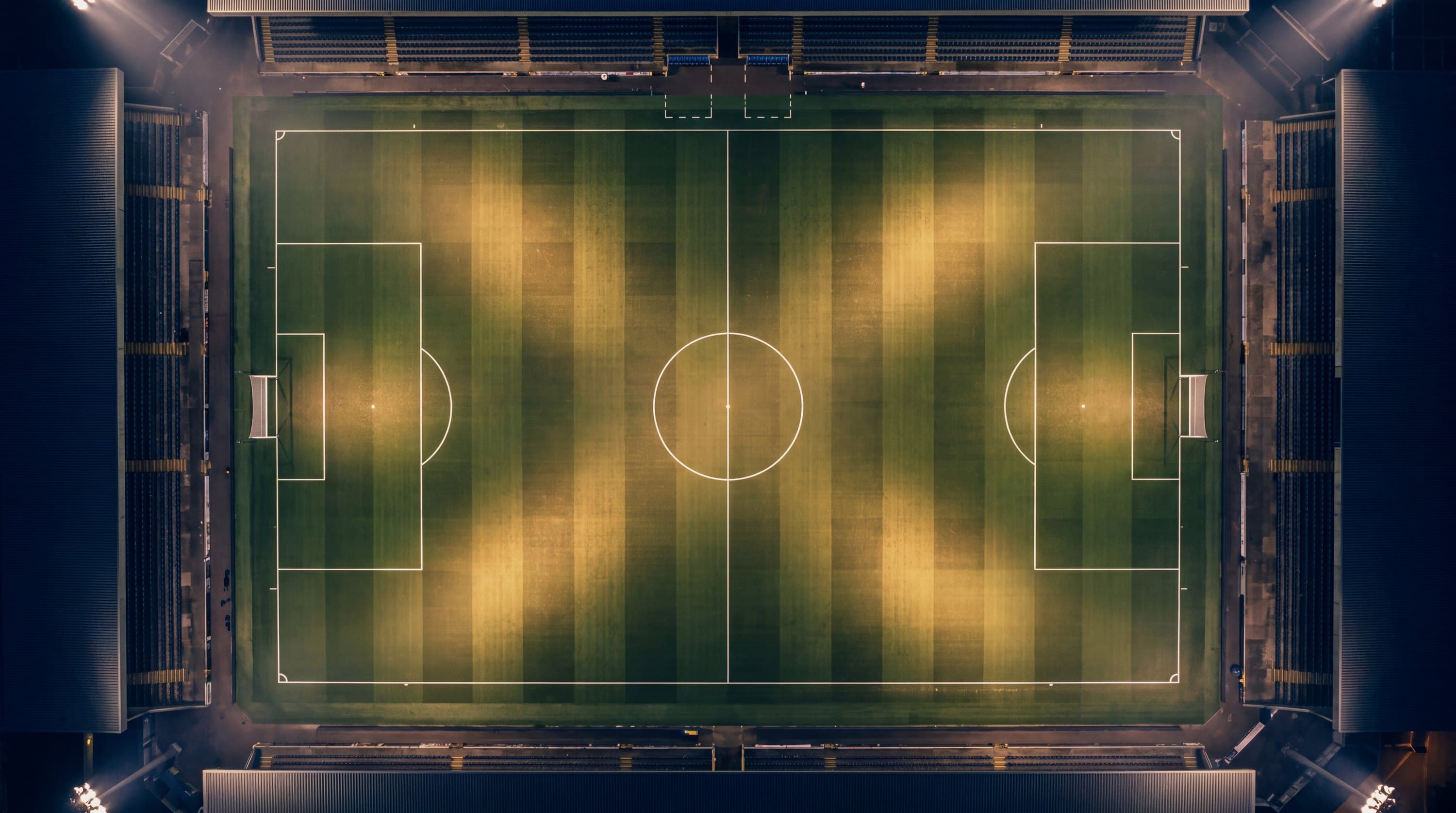Fußballfeld von oben bei Nacht, Linien als reine Geometrie im Flutlicht